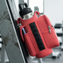 red crossbody bag attached to a metal bar in a gym setting