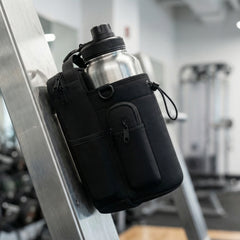 Water bottle with black holder attached to gym equipment