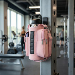 Pink crossbody bag attached to a metal bar in a gym setting