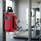 red crossbody bag attached to a metal bar in a gym setting